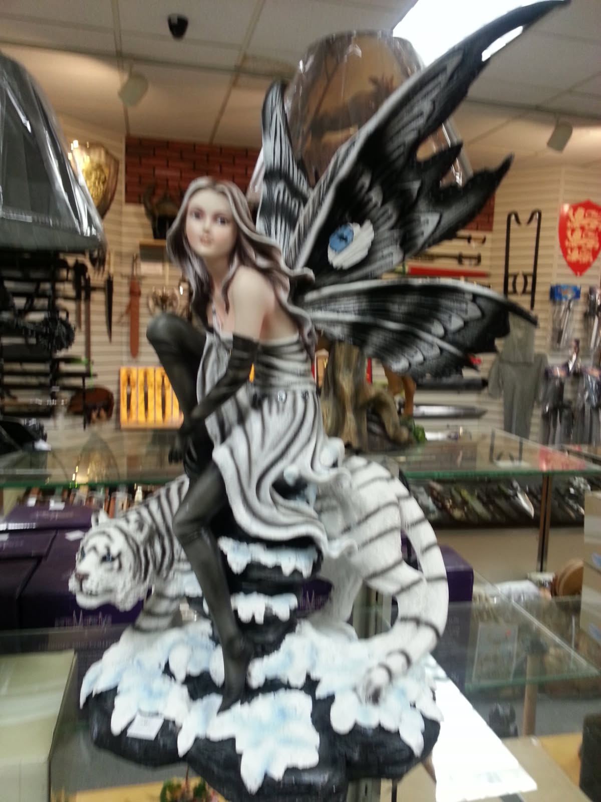 Black and white winged fairy figurine seated on a white tiger