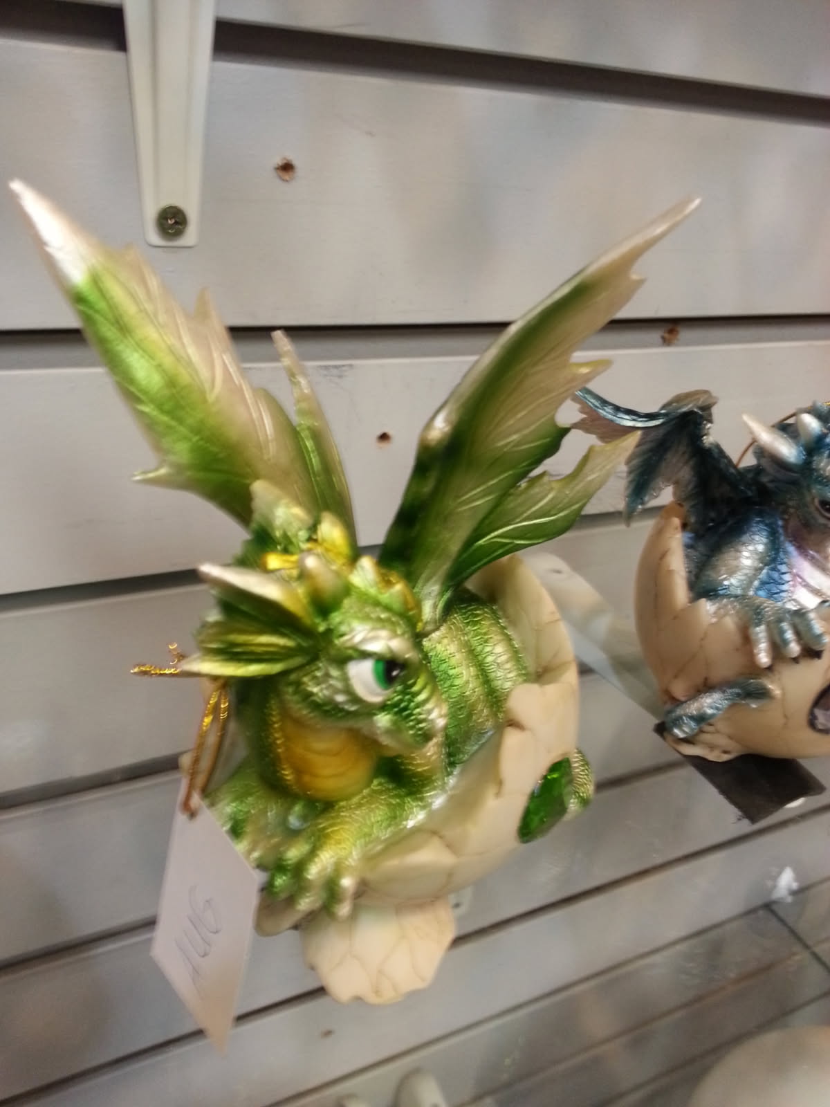 Green and blue baby dragon figurines hatching from cracked eggs