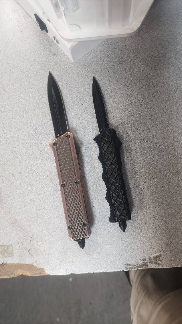 Two out-the-front automatic knives, one with a copper honeycomb handle and one in textured black