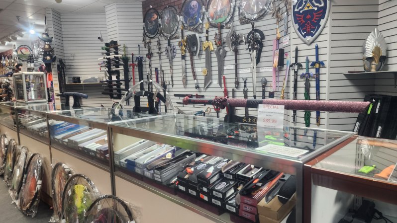 Sword wall above the glass counter with a red-wrapped katana marked on special