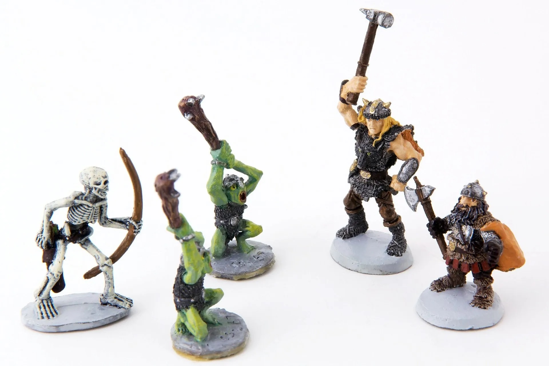 Hand-painted fantasy miniatures including a skeleton archer, goblins, a barbarian, and a dwarf